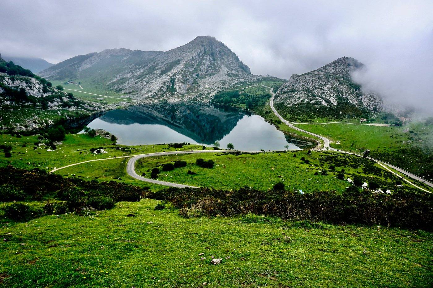 A mountain lake reflecting the surrounding peaks in the Cantabrian Mountains, the range that includes La Camperona