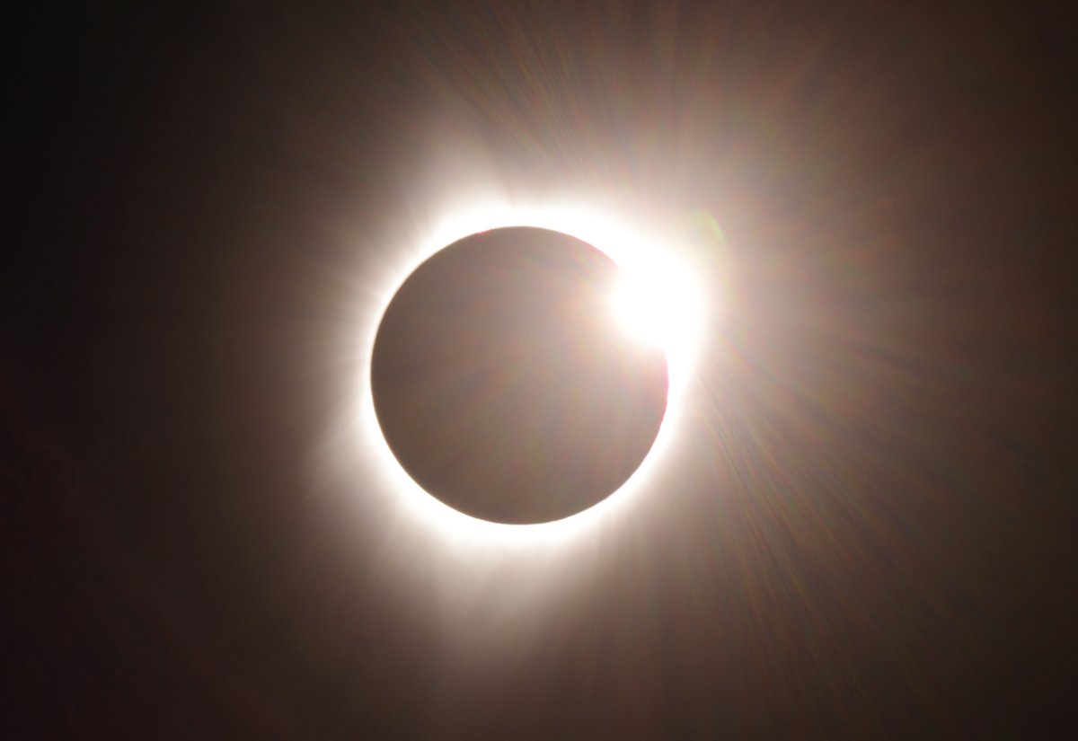 The diamond ring effect during a total solar eclipse, showing a bright bead of sunlight breaking through a lunar valley at the edge of totality
